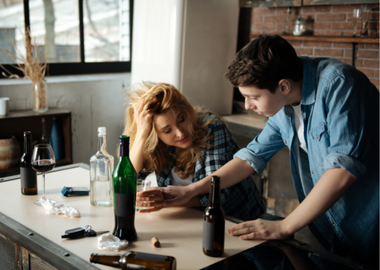 Teen boy stopping her mother from drinking too much