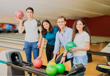 Friends poses with bowling balls